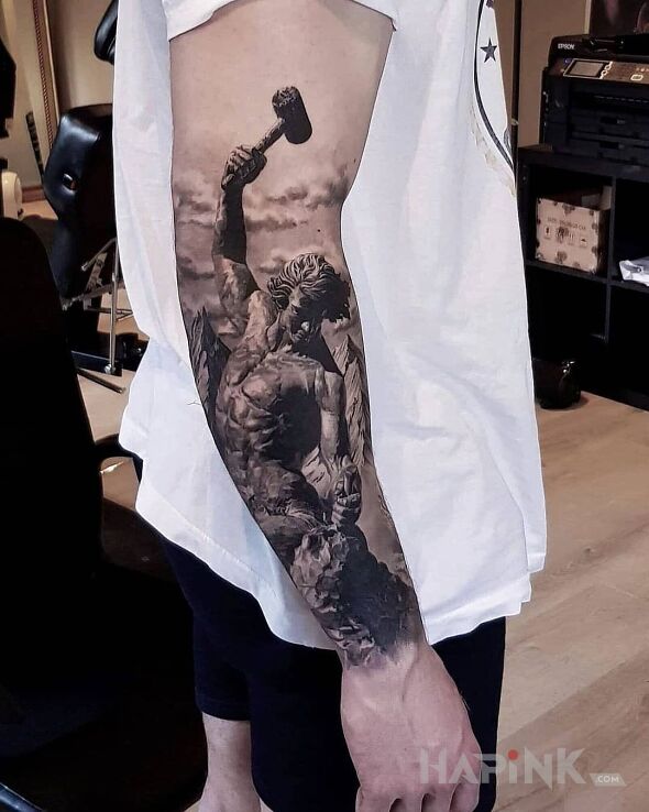 Tattoo Mlotem w kamien in characters motif and realistic style On the arm