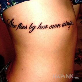 Tattoo She flies by her own wings on the ribs motif: lettering