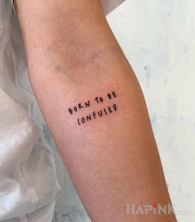 Tattoo Born to be confused in lettering motif and ignorant style on the forearm