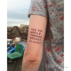 Tattoo Broken glasses lenses On the arm motif: lettering style: ignorant