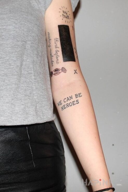 Tattoo Bohater in lettering motif and blackwork / blackout style On the arm