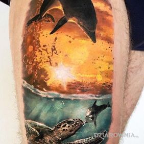 Tatuaż Delfin i zachód słońca na nodze motyw: zwierzęta styl: realistyczne