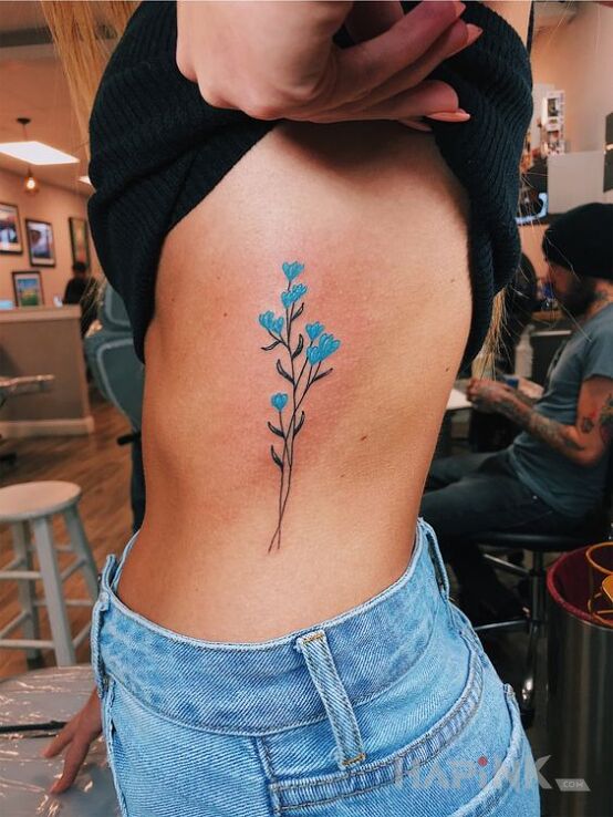 Tattoo Jasno niebieski kwiat in flowers motif and graphic / illustrative style on the ribs