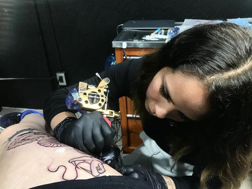 tatuażystka Yatzil Elizalde robiąca tatuaż na udzie