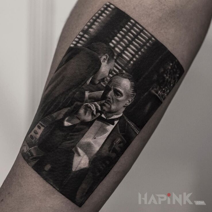 Tattoo Don Corleone in characters motif and realistic style on the forearm