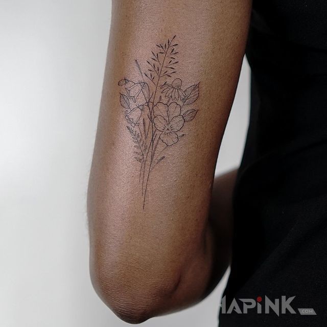 Tattoo Polne kwiaty in black and gray motif and minimalistic style on the upper arm