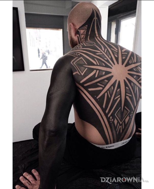Tatuaż gwiazda w motywie rękawy i stylu blackwork / blackout na karku