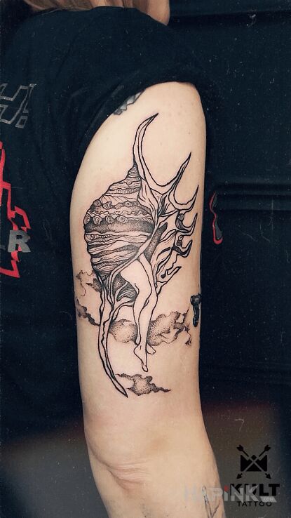 Tattoo MUSZLA in anatomical motif and graphic / illustrative style On the arm