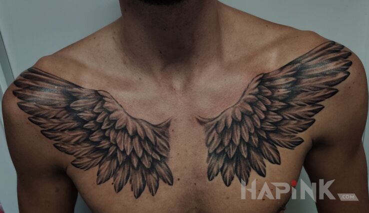 Tattoo Skrzydła in black and gray motif and realistic style on the collarbone
