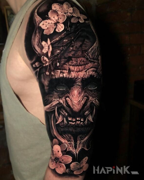 Tattoo Japoński demon in black and gray motif and realistic style On the arm