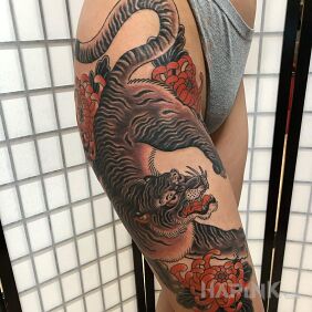 Tattoo Tiger in Japanese style on the thigh motif: flowers style: japanese / irezumi