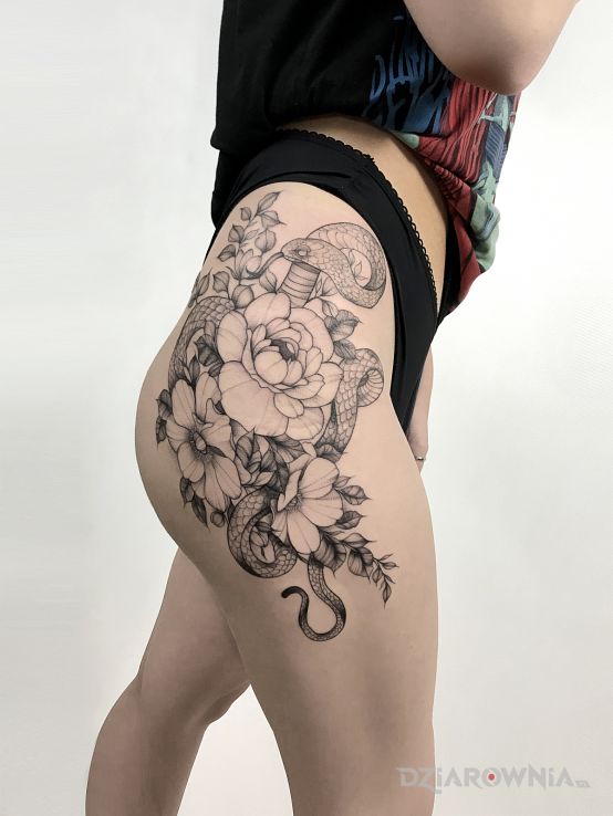 Tatuaż kompozycja z kwiatami i wężem w motywie czarno-szare i stylu blackwork / blackout na udzie
