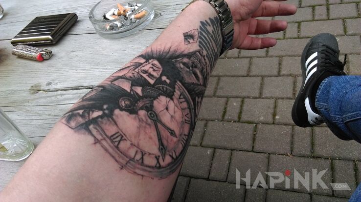 Tattoo Zegar in skulls motif on the forearm