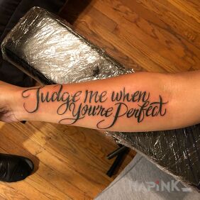 Tattoo Judging others on the forearm motif: lettering style: calligraphy
