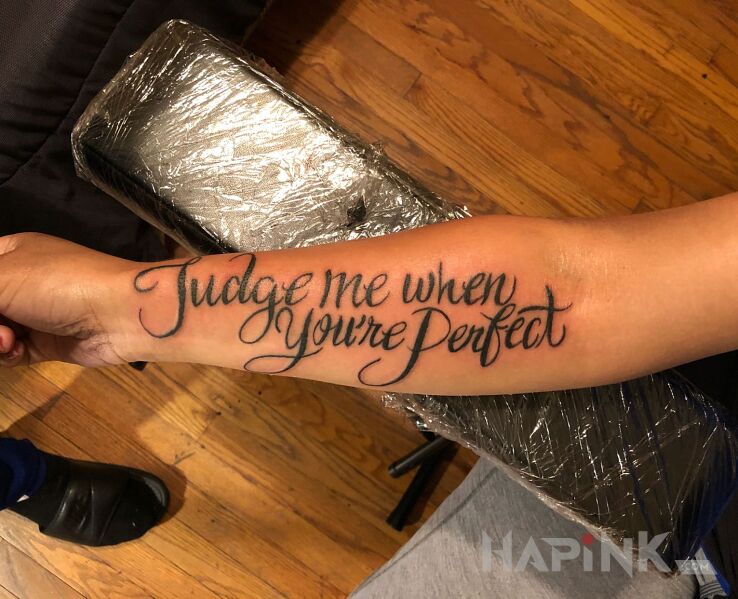 Tattoo Ocenianie innych in lettering motif and calligraphy style on the forearm