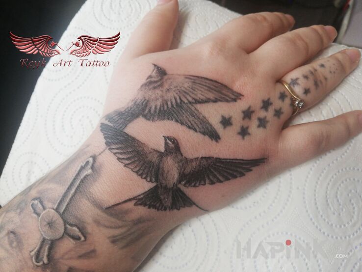 Tattoo Jaskoleczki in black and gray motif and realistic style on the hand