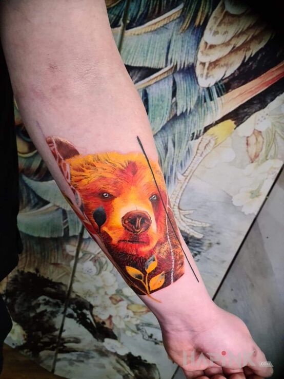 Tattoo Niedźwiedź in colorful motif and realistic style On the arm