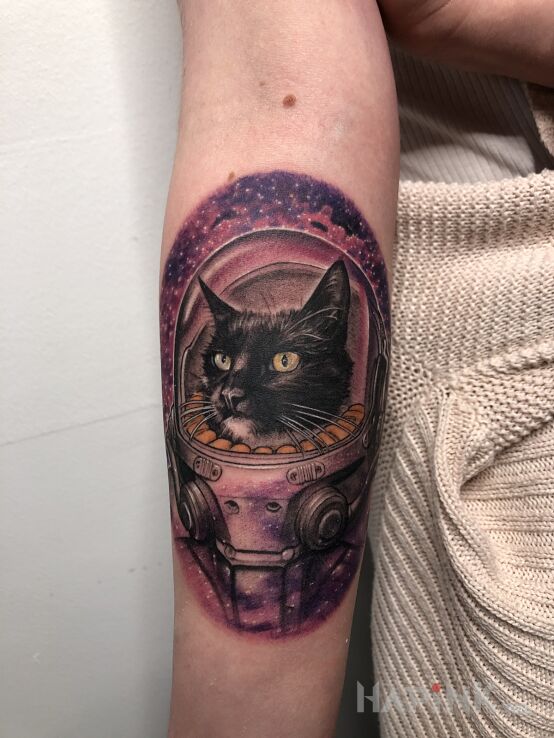 Tattoo Kosmiczny kot. in colorful motif and surrealistic style On the arm