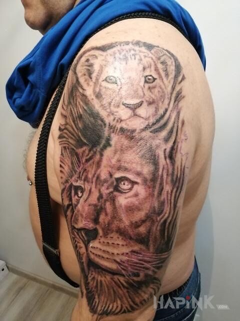 Tattoo Lew in black and gray motif and realistic style on the upper arm