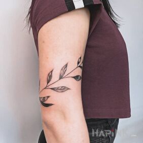 Tattoo Leaves on the upper arm motif: black and gray style: graphic / illustrative