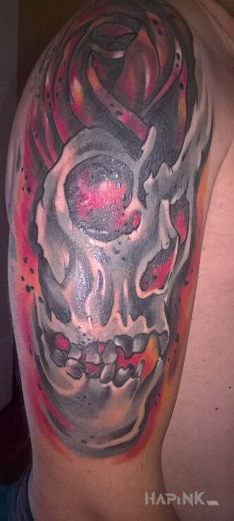 Tattoo Czaszka rozsadzana przez różę in skulls motif on the upper arm