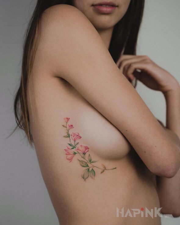 Tattoo Pąki kwiatów in flowers motif and realistic style on the ribs