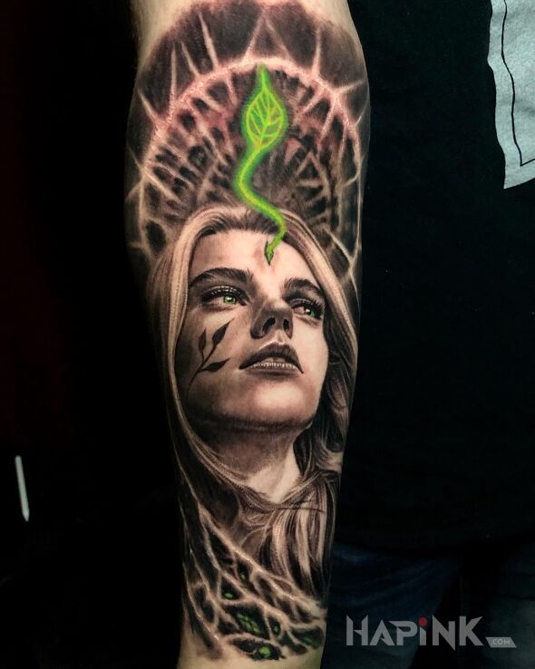 Tattoo Zielony listek wyrastający z czoła in faces motif and realistic style on the forearm