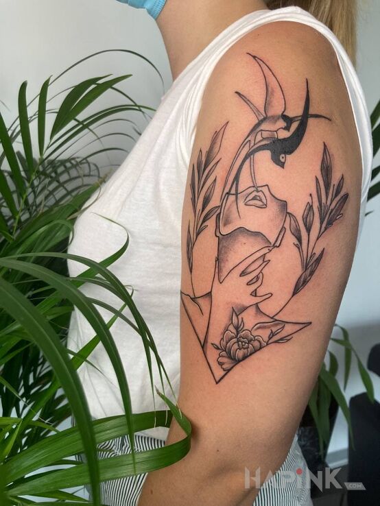 Tattoo Jaskółki tatuaż in flowers motif and graphic / illustrative style on the upper arm