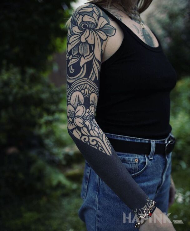Tattoo Kwiaty z czarnym in sleeves motif and blackwork / blackout style on the forearm