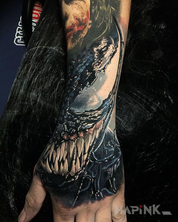 Tattoo Uśmiech Venoma in characters motif and realistic style on the forearm