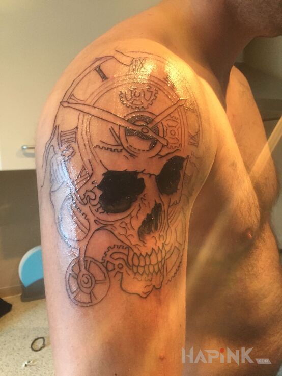 Tattoo A to na dobre zakonczenie in skulls motif on the upper arm