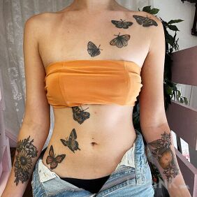 Tattoo Butterflies flying on the torso on the stomach motif: colorful style: realistic