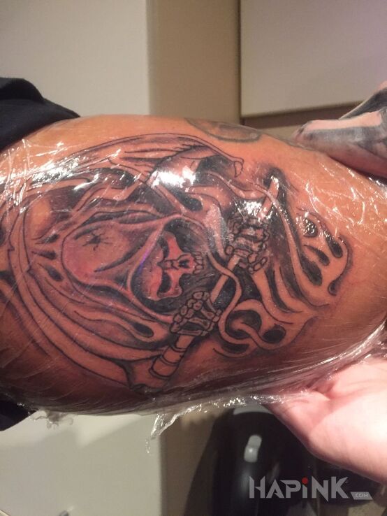 Tattoo Kostucha in skulls motif on the upper arm