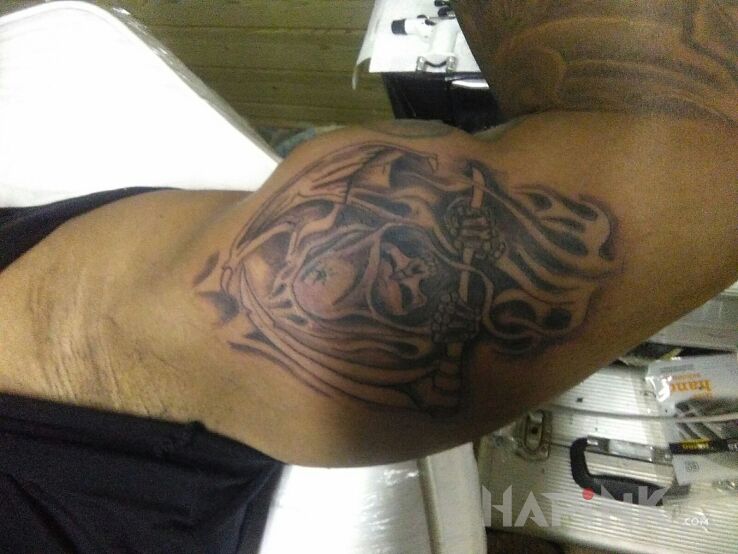 Tattoo Kostucha in skulls motif on the upper arm