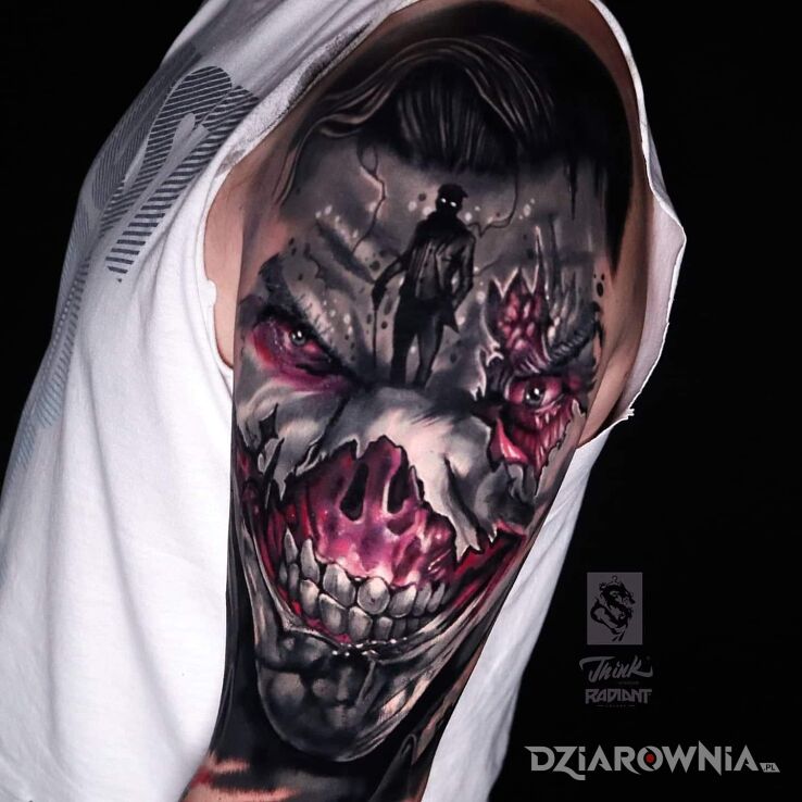 Tatuaż joker w motywie fantasy i stylu realistyczne na ramieniu