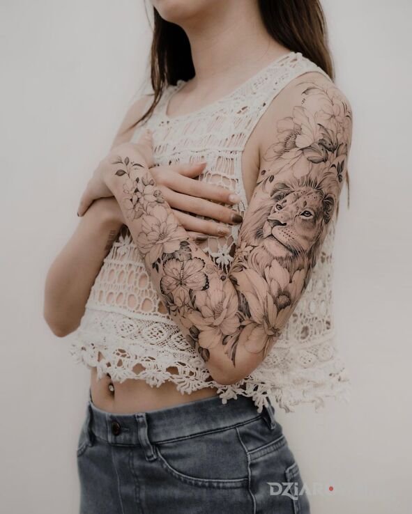 Tatuaż lew w krainie kwiatów w motywie kwiaty i stylu realistyczne na przedramieniu