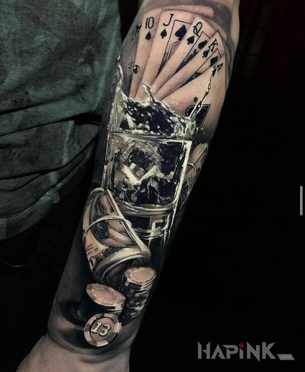 Tattoo Alko i hazard in black and gray motif and realistic style On the arm