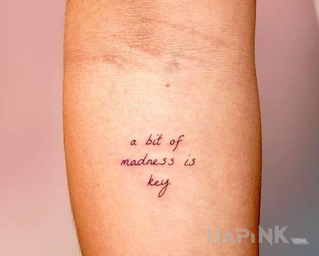 Tattoo Ociupinka szaleństwa in lettering motif and calligraphy style on the forearm
