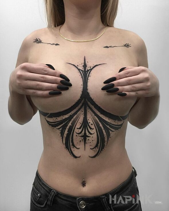Tattoo Maźnięte na czarno in other motif and blackwork / blackout style between the breasts