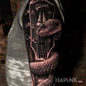 Tattoo Gibson guitar on the upper arm motif: animals style: realistic