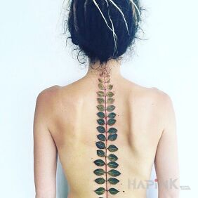 Tattoo Green branch on the back motif: flowers