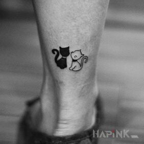 Tattoo Black and white cat on the leg motif: black and gray style: minimalistic