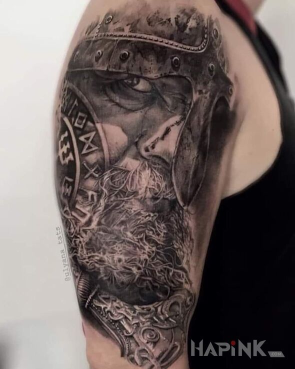 Tattoo Wiking in faces motif and realistic style on the upper arm