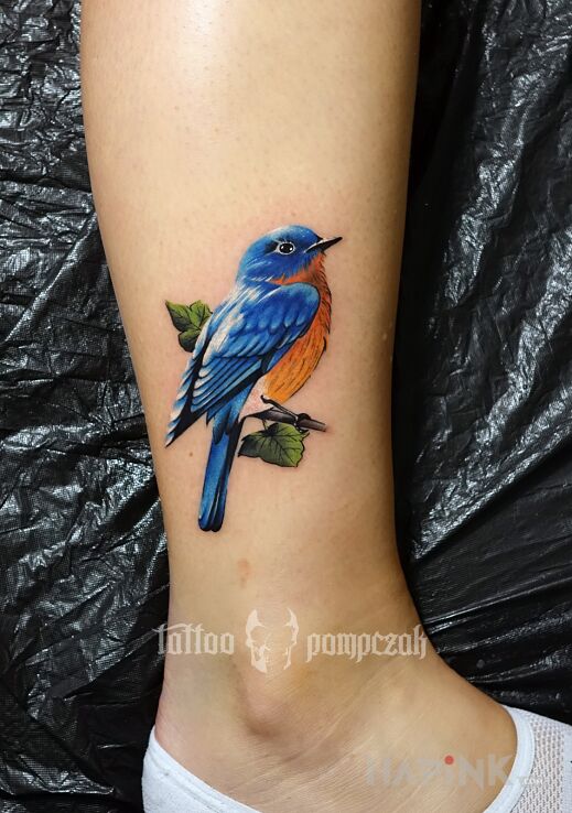 Tattoo Eastern bluebird in colorful motif and realistic style on the leg