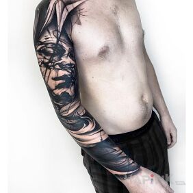 Tattoo Smeared face on the upper arm motif: black and gray style: blackwork / blackout