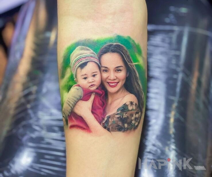 Tattoo Matka z dzieckiem in faces motif and realistic style On the arm