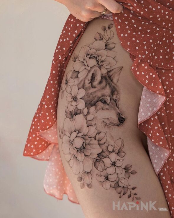 Tattoo Wilczku in flowers motif and realistic style on the hip