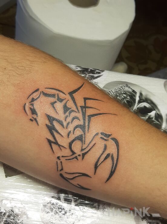Tattoo Scorpion in animals motif and tribal style on the forearm