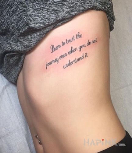 Tattoo Naucz sie ufac in lettering motif and calligraphy style on the ribs