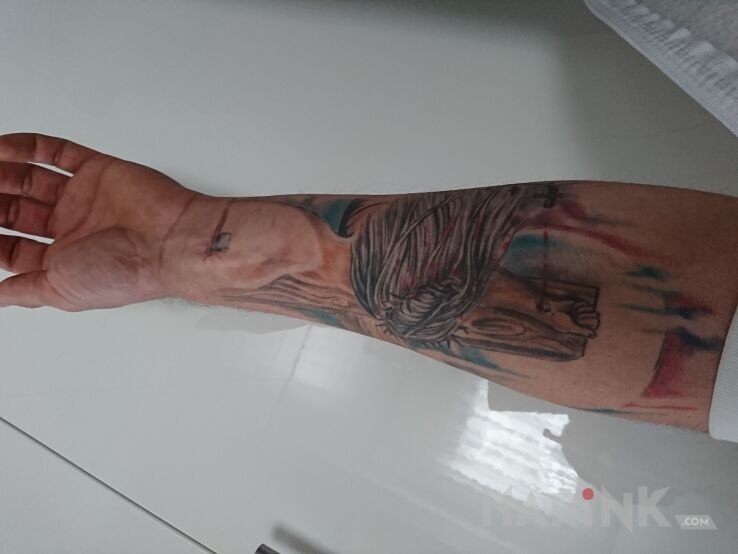 Tattoo Jest in religious motif on the forearm
